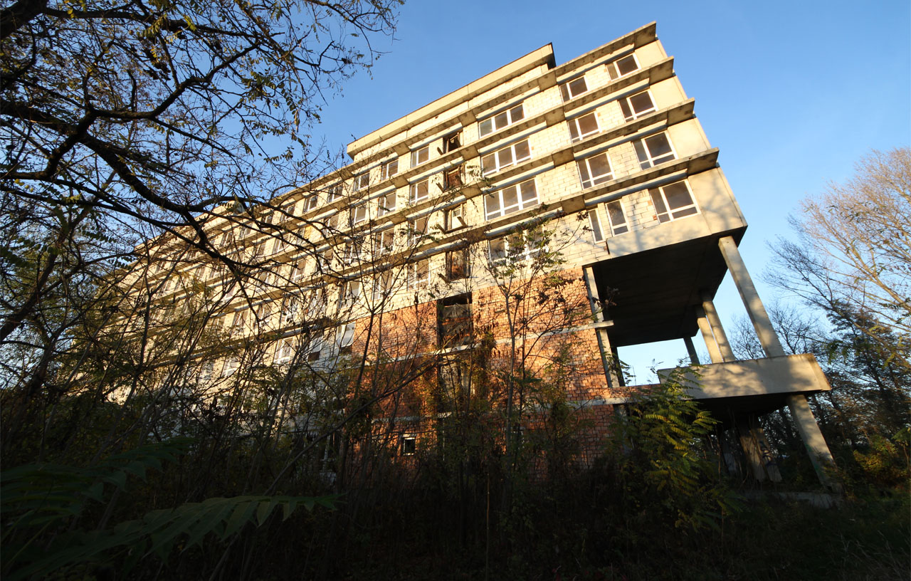 Dokonce ani sloupy podepírající portikus rozepnutý na výši dvou podlaží nejsou kulaté ale přísně hranolové. Tudy měl kdysi proudit živý ruch zaměstnanců v bílých pláštích a modrých uniformách, jakož i návštěvníků zdravých i nemocných.