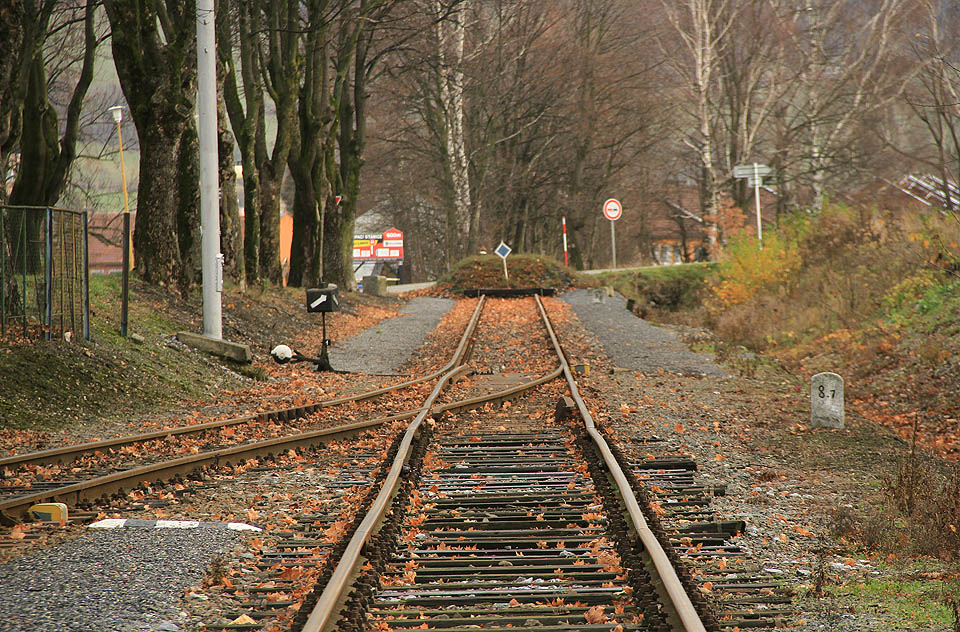 Ukončení koleje č. 1a v km 8,822 před bývalým přejezdem přes Nádražní ulici. Dráha dřív pokračovala ještě o cca 600 m dál do areálu pily. Plánované prodloužení okolo <a href="/Tema/Zlaté Hory">města</a> a tunelem pod Biskupskou kupou do <a href="/Tema/Jindřichov ve Slezsku (žst)">Jindřichova</a> se nikdy neuskutečnilo.