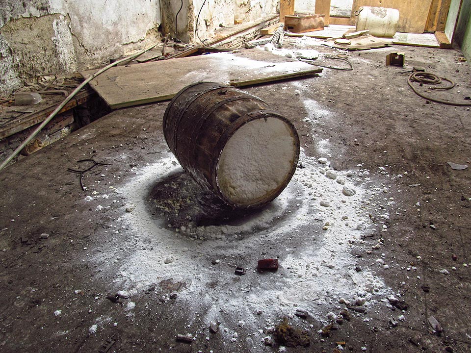 Těžko říct, zda starý dřevěný sud ukrývá nálož karcinogenních pesticidů nebo jen neškodný škrob. Vinětu dávno odvál čas. Někdo před námi jej roztočil a prášek vytvořil na podlaze zajímavou kresbu.