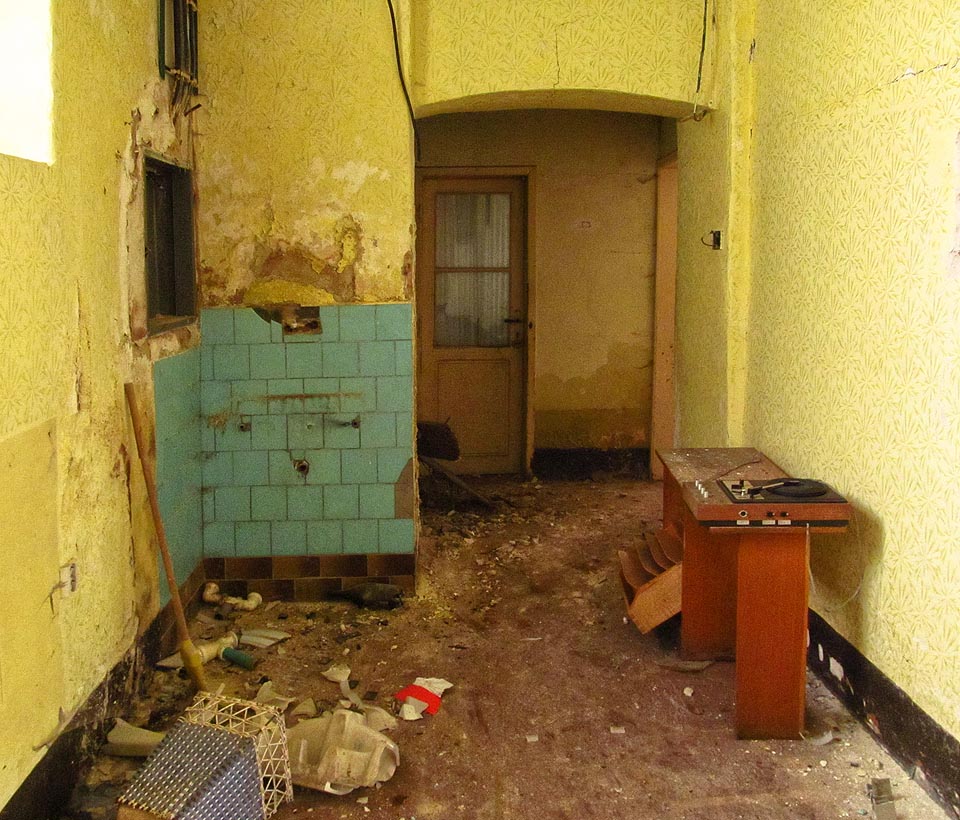 Tady to vypadá jako byt správce, původní =učel budovy je však těžko odhadovat. Gramofon dohrál už před mnoha léty.